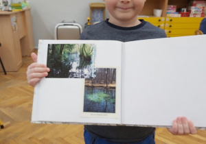 Chłopiec pokazuje album o Tomaszowie Maz.